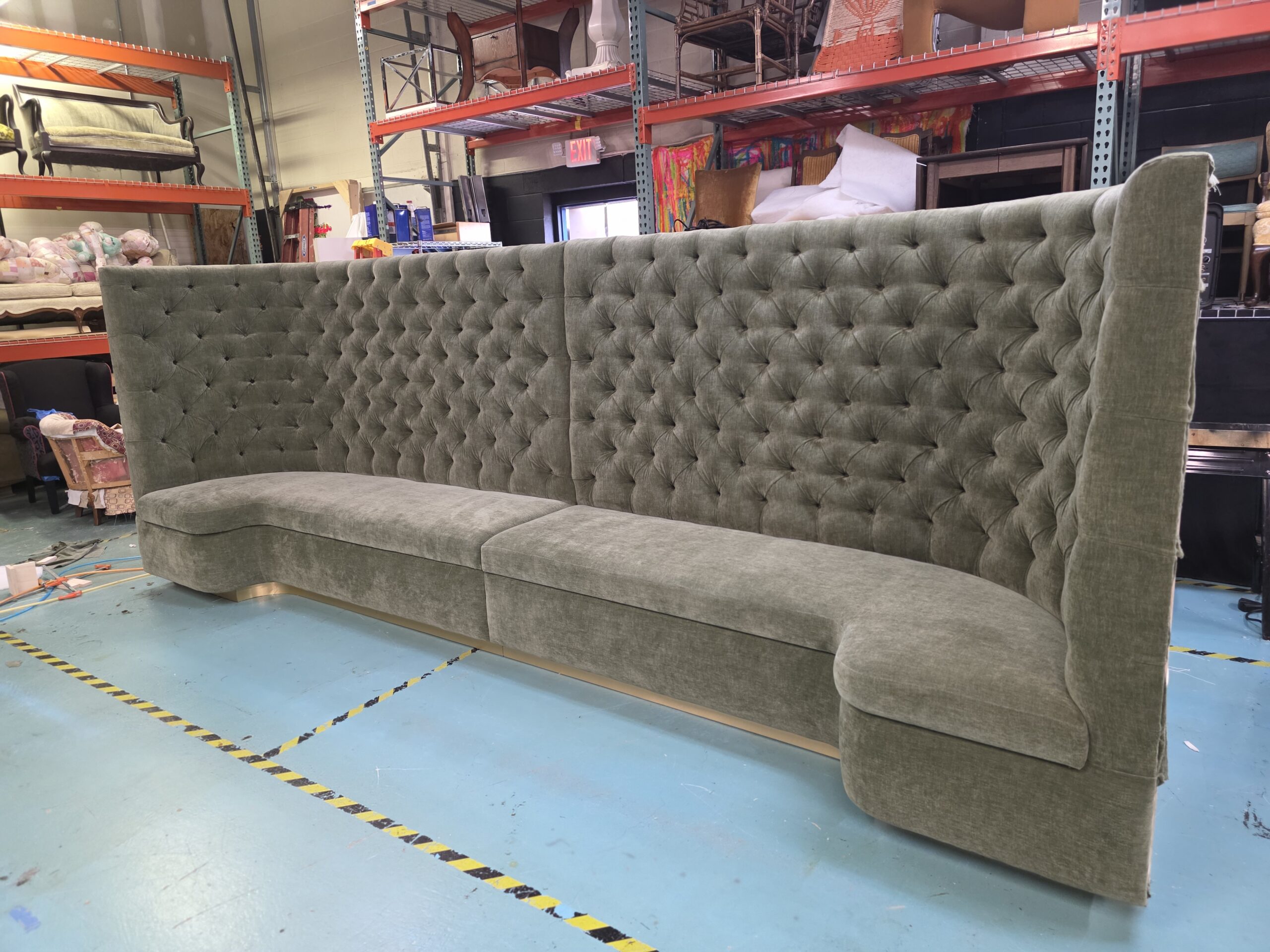 Custom curved tufted banquette seating upholstered in gray-green velvet inside LullCo Design Studio.